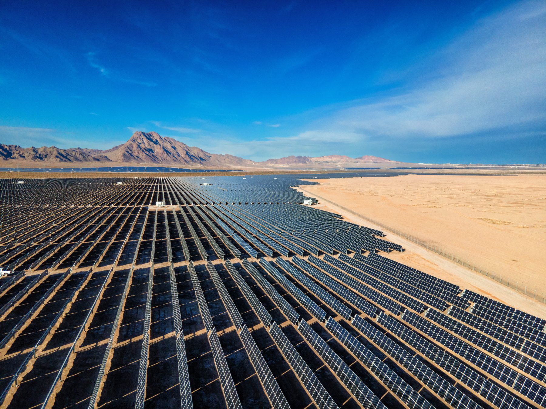 A large coastal solar array under a clear sky